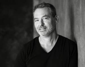 Mann in schwarzem T-Shirt, Fokus auf Männergesundheit und Wohlbefinden.