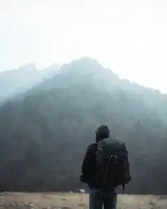 Abenteurer mit Rucksack blickt auf Berglandschaft, Natur, Wandern, Freiheit.