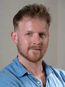 Mann mit Bart und blauer Hemd, Selbstbewusst und freundlich.