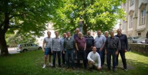 Gruppe von Männern im Park bei MALEvolution, umgeben von Bäumen und Natur.