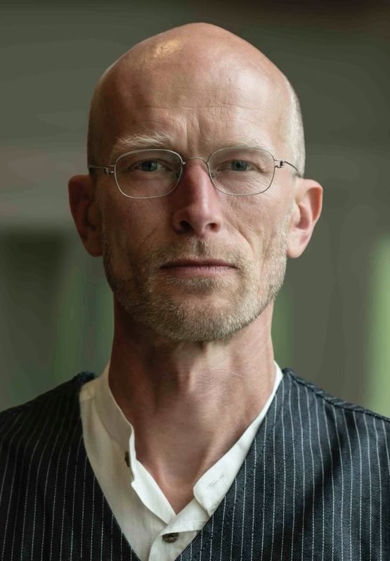 Mann mit Brille und ernstem Blick, männlich, professionell, Selbstbewusst.