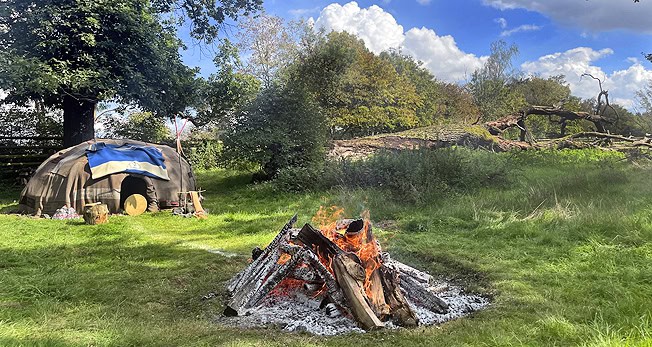 Männer beim Lagerfeuer im Grünen während eines Intensivtags.